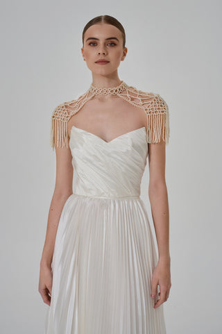 Elegant pearl backpacks with a lace-like woven structure and movable fringes that add aristocratic sophistication to the look