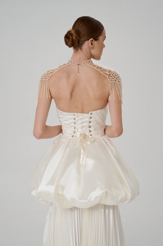 Elegant pearl backpacks with a lace-like woven structure and movable fringes that add aristocratic sophistication to the look