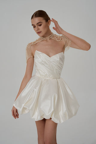 Elegant pearl backpacks with a lace-like woven structure and movable fringes that add aristocratic sophistication to the look