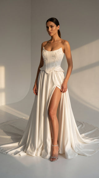Strapless wedding dress with a basque corset, deep slit, and long train - designer piece by Caribis
