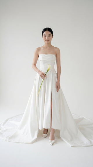 Wedding dress-transformer with a deep cut and a semi-circular long train