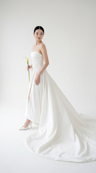 Wedding dress-transformer with a deep cut and a semi-circular long train
