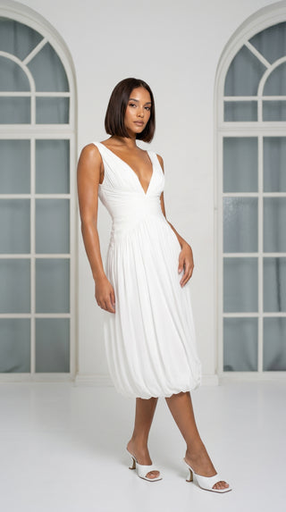 A light dress with draping and an open back that combines femininity and comfort