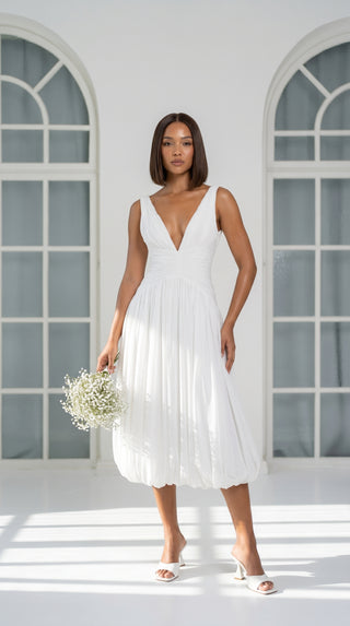 A light dress with draping and an open back that combines femininity and comfort
