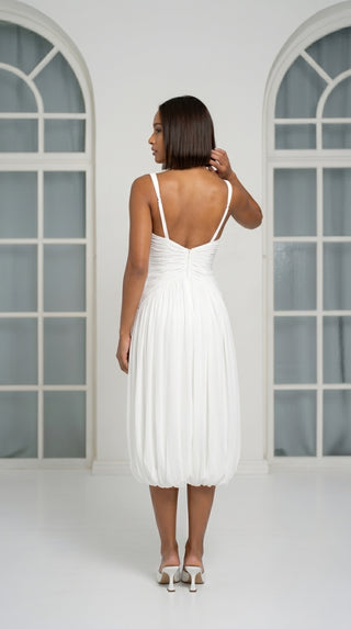 A light dress with draping and an open back that combines femininity and comfort
