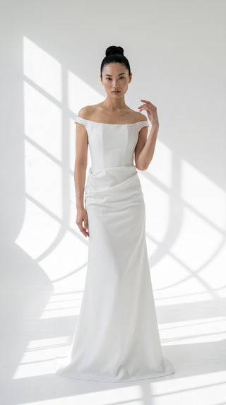 An elegant dress with open shoulders and a draped skirt that combines minimalism and sophistication