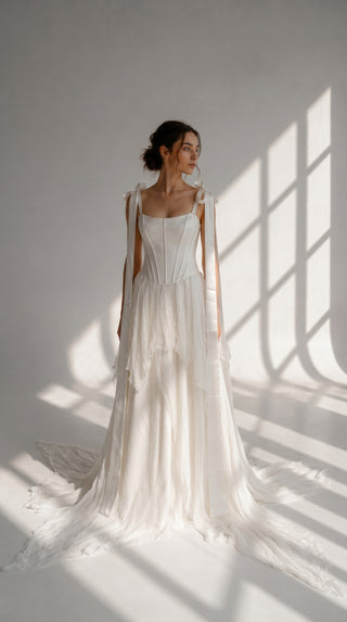 A sophisticated ivory two-piece with a structured satin bodice and a light silk skirt is a versatile choice for the modern bride