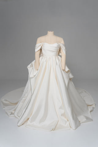 A luxurious dress with open shoulders and a lush train skirt for an elegant and majestic wedding look