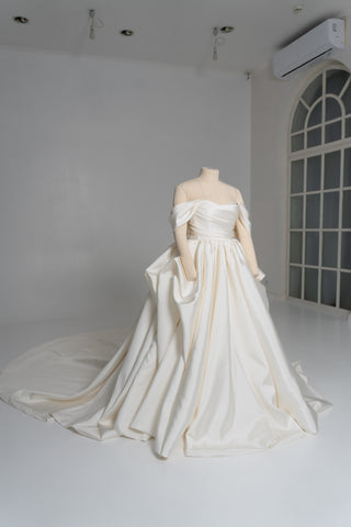 A luxurious dress with open shoulders and a lush train skirt for an elegant and majestic wedding look