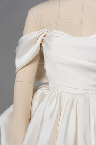 A luxurious dress with open shoulders and a lush train skirt for an elegant and majestic wedding look