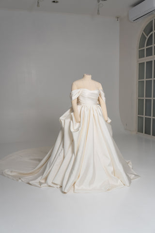A luxurious dress with open shoulders and a lush train skirt for an elegant and majestic wedding look