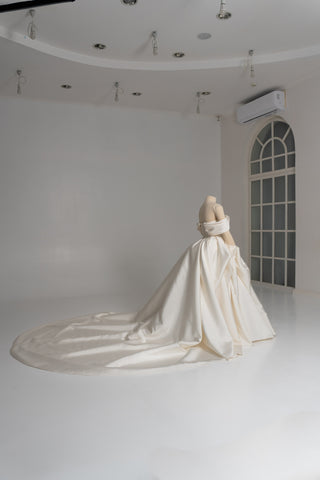 A luxurious dress with open shoulders and a lush train skirt for an elegant and majestic wedding look