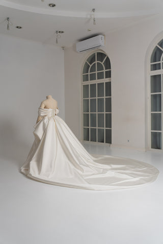 A luxurious dress with open shoulders and a lush train skirt for an elegant and majestic wedding look