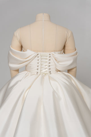 A luxurious dress with open shoulders and a lush train skirt for an elegant and majestic wedding look