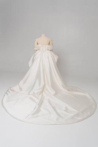 A luxurious dress with open shoulders and a lush train skirt for an elegant and majestic wedding look