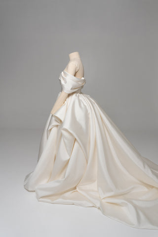 A luxurious dress with open shoulders and a lush train skirt for an elegant and majestic wedding look