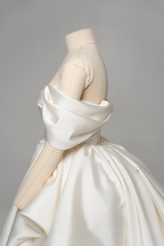 A luxurious dress with open shoulders and a lush train skirt for an elegant and majestic wedding look