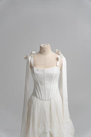 A sophisticated ivory two-piece with a structured satin bodice and a light silk skirt is a versatile choice for the modern bride