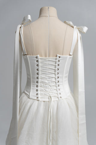 A sophisticated ivory two-piece with a structured satin bodice and a light silk skirt is a versatile choice for the modern bride