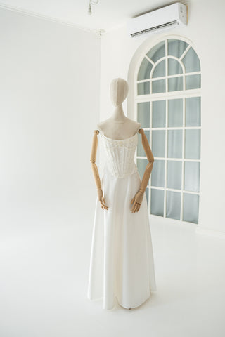 An elegant wedding set with minimalist embroidery — a corset with pearls and a straight skirt