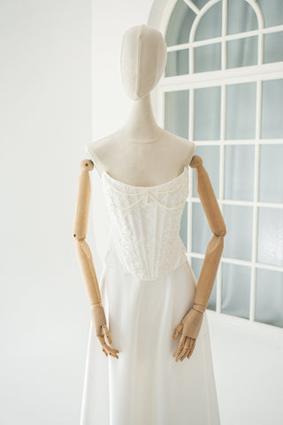 An elegant wedding set with minimalist embroidery — a corset with pearls and a straight skirt