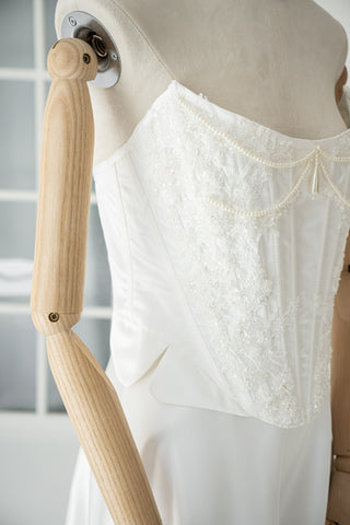 An elegant wedding set with minimalist embroidery — a corset with pearls and a straight skirt