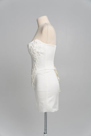 Short wedding dress with an elongated corset, floral embroidery, and an asymmetrical silhouette