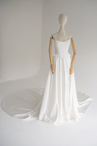 Strapless wedding dress with a basque corset, deep slit, and long train