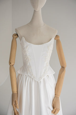 Strapless wedding dress with a basque corset, deep slit, and long train