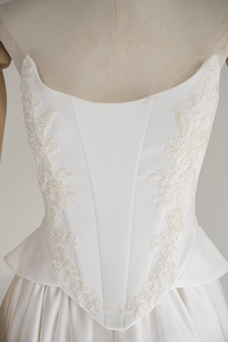 Strapless wedding dress with a basque corset, deep slit, and long train - designer piece by Caribis
