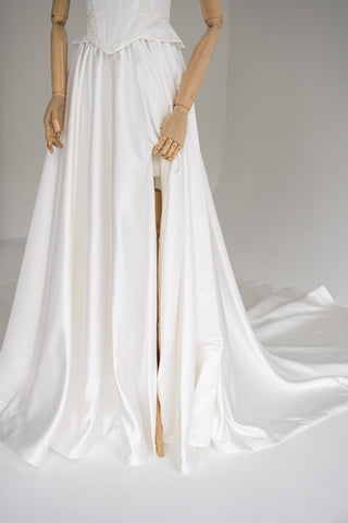Strapless wedding dress with a basque corset, deep slit, and long train