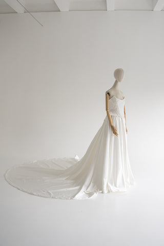 Strapless wedding dress with a basque corset, deep slit, and long train