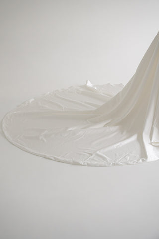 Strapless wedding dress with a basque corset, deep slit, and long train