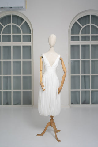 A light dress with draping and an open back that combines femininity and comfort