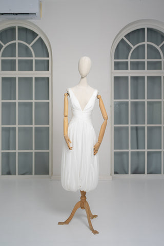 A light dress with draping and an open back that combines femininity and comfort