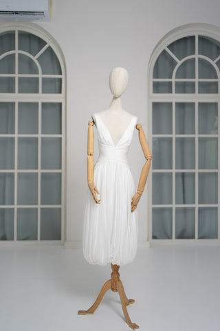 A light dress with draping and an open back that combines femininity and comfort