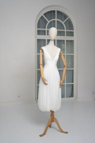 A light dress with draping and an open back that combines femininity and comfort
