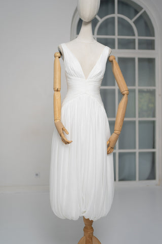 A light dress with draping and an open back that combines femininity and comfort