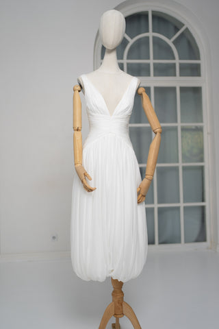 A light dress with draping and an open back that combines femininity and comfort