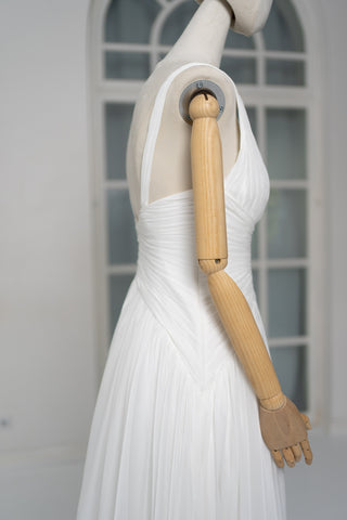 A light dress with draping and an open back that combines femininity and comfort