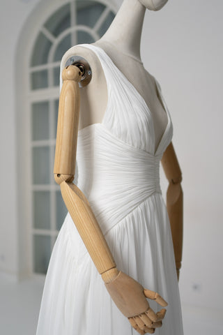 A light dress with draping and an open back that combines femininity and comfort