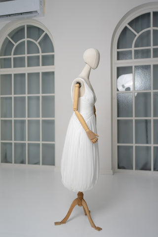 A light dress with draping and an open back that combines femininity and comfort