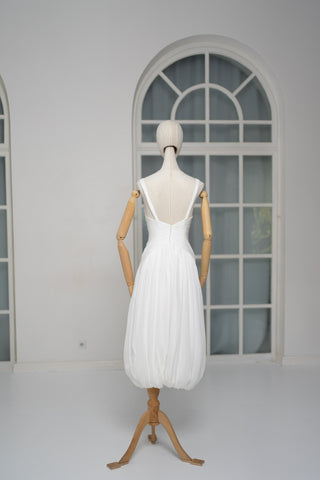 A light dress with draping and an open back that combines femininity and comfort