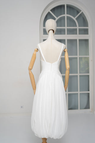 A light dress with draping and an open back that combines femininity and comfort