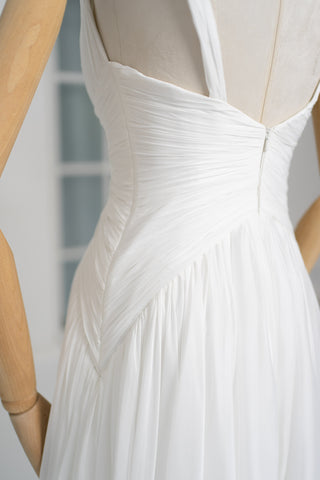 A light dress with draping and an open back that combines femininity and comfort
