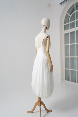 A light dress with draping and an open back that combines femininity and comfort