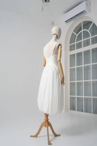 A light dress with draping and an open back that combines femininity and comfort