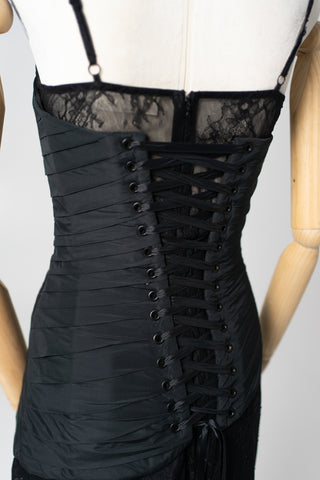 An exquisite black corset set with tulle texture and a luxurious train that creates a dramatic and architectural silhouette