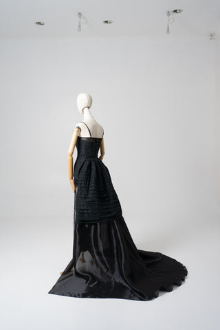 An exquisite black corset set with tulle texture and a luxurious train that creates a dramatic and architectural silhouette