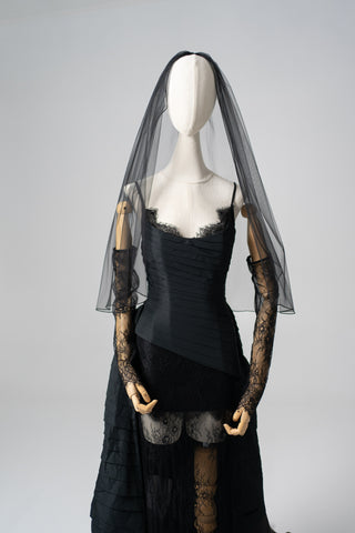 An exquisite black corset set with tulle texture and a luxurious train that creates a dramatic and architectural silhouette